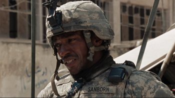 Movie still from “The Hurt Locker” (2008), directed by Kathryn Bigelow – A man in a military uniform is smiling for the camera; Close Up shot, Over the shoulder angle