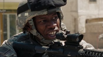 Movie still from “The Hurt Locker” (2008), directed by Kathryn Bigelow – A man in a helmet is holding a rifle; Close Up shot, Low angle