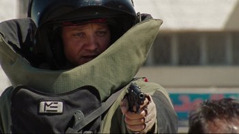 Movie still from “The Hurt Locker” (2008), directed by Kathryn Bigelow – A person in a helmet holding a gun; Close Up shot, Over the shoulder angle