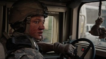 Movie still from “The Hurt Locker” (2008), directed by Kathryn Bigelow – A man in military fatigues driving a vehicle; Close Up shot, Over the shoulder angle