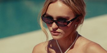 Movie still from “The Idol” (2023), directed by Sam Levinson – A woman wearing sunglasses and a pearl necklace; Close Up shot, Over the shoulder angle