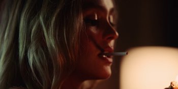 Movie still from “The Idol” (2023), directed by Sam Levinson – A person holding a cigarette in her mouth; Extreme Close Up shot, Over the shoulder angle