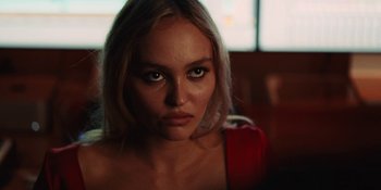 Movie still from “The Idol” (2023), directed by Sam Levinson – A beautiful young woman with long blonde hair and green eyes; Close Up shot, Over the shoulder angle