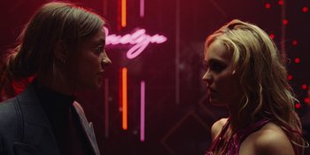 Movie still from “The Idol” (2023), directed by Sam Levinson – Two women are facing each other in front of a neon sign; Close Up shot, Over the shoulder angle