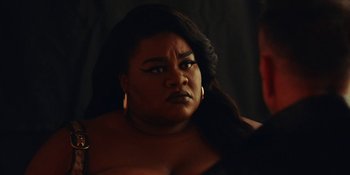 Movie still from “The Idol” (2023), directed by Sam Levinson – A black woman with long black hair and big breast; Close Up shot, Over the shoulder angle