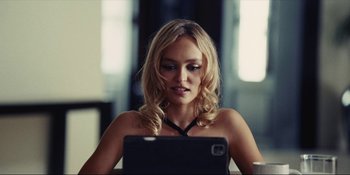 Movie still from “The Idol” (2023), directed by Sam Levinson – A beautiful blonde woman sitting in front of a laptop; Close Up shot, Over the shoulder angle