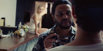 Movie still from “The Idol” (2023), directed by Sam Levinson – A man with long hair is looking at a woman; Close Up shot, Over the shoulder angle