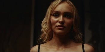 Movie still from “The Idol” (2023), directed by Sam Levinson – A woman with blonde hair is looking at the camera; Close Up shot, Over the shoulder angle