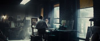 Movie still from “Bridge of Spies” (2015), directed by Steven Spielberg – A man standing in front of an easel in front of a window; Wide shot, Low angle