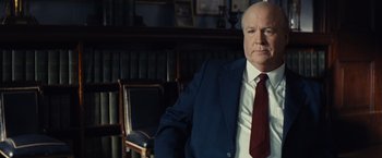 Movie still from “Bridge of Spies” (2015), directed by Steven Spielberg – A man in a suit and tie in front of a bookshelf; Medium shot, Over the shoulder angle