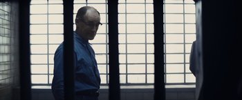 Movie still from “Bridge of Spies” (2015), directed by Steven Spielberg – A man standing in front of bars in a jail cell; Medium shot, Low angle