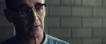 Movie still from “Bridge of Spies” (2015), directed by Steven Spielberg – An older man wearing glasses looking at the camera; Close Up shot, Over the shoulder angle