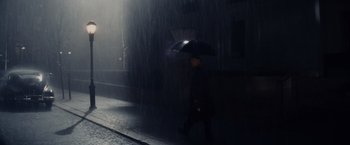 Movie still from “Bridge of Spies” (2015), directed by Steven Spielberg – A man walking down the street holding an umbrella; Extreme Wide shot, Low angle