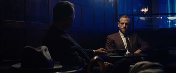 Movie still from “Bridge of Spies” (2015), directed by Steven Spielberg – Two men in suits sitting at a table talking to each other; Medium shot, Over the shoulder angle