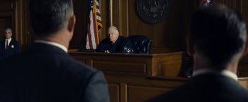 Movie still from “Bridge of Spies” (2015), directed by Steven Spielberg – A judge sitting at a table in a courtroom; Medium shot, Over the shoulder angle