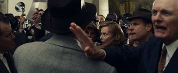 Movie still from “Bridge of Spies” (2015), directed by Steven Spielberg – A woman in a suit and a hat standing next to a man in a suit; Close Up shot, Over the shoulder angle