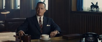 Movie still from “Bridge of Spies” (2015), directed by Steven Spielberg – A man in a suit sitting at a table with a cup of coffee; Close Up shot, Over the shoulder angle