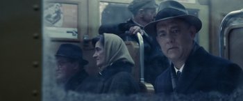 Movie still from “Bridge of Spies” (2015), directed by Steven Spielberg – A group of people sitting on a train; Close Up shot, Over the shoulder angle