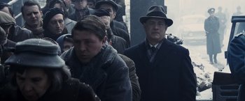 Movie still from “Bridge of Spies” (2015), directed by Steven Spielberg – A group of people in coats and a hat; Medium shot, Over the shoulder angle