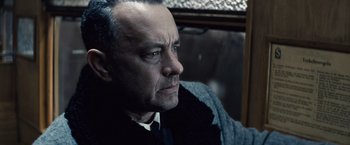 Movie still from “Bridge of Spies” (2015), directed by Steven Spielberg – A man in a suit and tie sitting in front of a window; Close Up shot, Over the shoulder angle