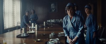 Movie still from “Bridge of Spies” (2015), directed by Steven Spielberg – Two women sitting at a table in front of a portrait; Medium shot, Low angle
