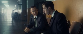 Movie still from “Bridge of Spies” (2015), directed by Steven Spielberg – Two men in business suits sitting next to each other; Medium shot, Over the shoulder angle