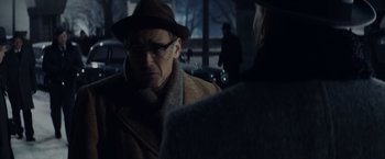 Movie still from “Bridge of Spies” (2015), directed by Steven Spielberg – A man wearing a hat and glasses talking to another man; Close Up shot, Over the shoulder angle