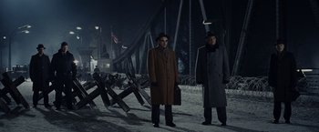 Movie still from “Bridge of Spies” (2015), directed by Steven Spielberg – Two men standing next to each other on a bridge at night; Wide shot, Low angle