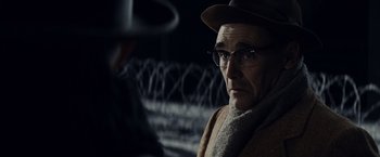 Movie still from “Bridge of Spies” (2015), directed by Steven Spielberg – An older man wearing a hat and glasses; Close Up shot, Over the shoulder angle