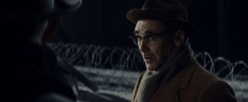 Movie still from “Bridge of Spies” (2015), directed by Steven Spielberg – An old man wearing glasses and a hat; Close Up shot, Over the shoulder angle