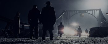 Movie still from “Bridge of Spies” (2015), directed by Steven Spielberg – A group of men standing on top of a snow covered ground; Wide shot, Low angle