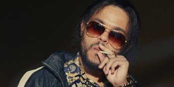 Movie still from “The Idol” (2023), directed by Sam Levinson – A man with sunglasses smoking a cigarette in his mouth; Close Up shot, Low angle