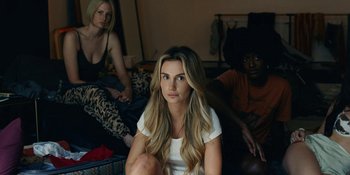 Movie still from “The Idol” (2023), directed by Sam Levinson – A woman sitting on the ground in front of two other women; Medium shot, High angle