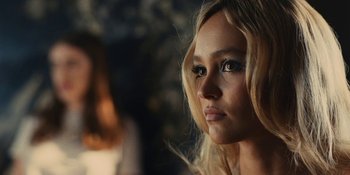 Movie still from “The Idol” (2023), directed by Sam Levinson – A beautiful young blond woman with blue eyes; Close Up shot, Over the shoulder angle