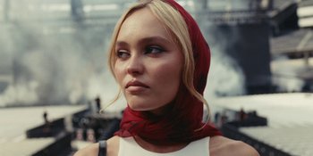 Movie still from “The Idol” (2023), directed by Sam Levinson – A woman wearing a red head scarf and a white top; Close Up shot, Low angle