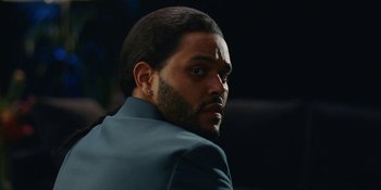 Movie still from “The Idol” (2023), directed by Sam Levinson – A person wearing a suit; Close Up shot, Low angle