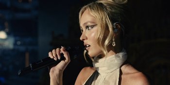 Movie still from “The Idol” (2023), directed by Sam Levinson – A beautiful blonde woman holding a microphone and singing; Close Up shot, Low angle