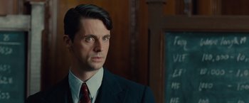 Movie still from “The Imitation Game” (2014), directed by Morten Tyldum – A man in a suit and tie in front of a chalkboard; Close Up shot, Over the shoulder angle