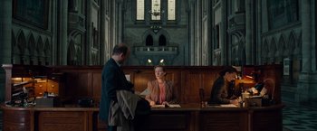 Movie still from “The Imitation Game” (2014), directed by Morten Tyldum – A woman sitting at a desk in a church; Wide shot, Low angle
