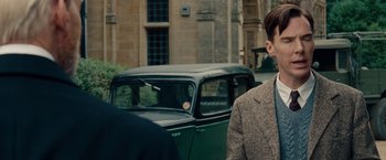 Movie still from “The Imitation Game” (2014), directed by Morten Tyldum – A man standing next to an old green car; Close Up shot, Over the shoulder angle