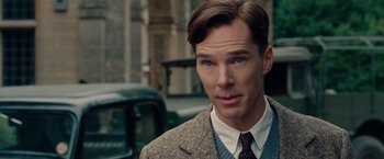 Movie still from “The Imitation Game” (2014), directed by Morten Tyldum – A man in a suit and tie standing in front of a car; Close Up shot, Over the shoulder angle