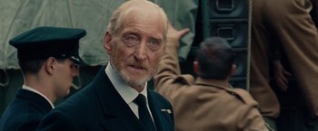 Movie still from “The Imitation Game” (2014), directed by Morten Tyldum – An old man with a beard and a white mustache; Close Up shot, Over the shoulder angle
