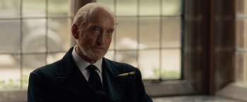 Movie still from “The Imitation Game” (2014), directed by Morten Tyldum – An older man wearing a suit and tie; Close Up shot, Low angle