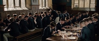 Movie still from “The Imitation Game” (2014), directed by Morten Tyldum – A group of young men sitting at a table eating food; Wide shot, High angle