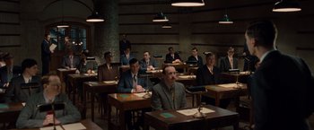 Movie still from “The Imitation Game” (2014), directed by Morten Tyldum – A group of people sitting at desks in a room; Wide shot, High angle