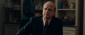 Movie still from “The Imitation Game” (2014), directed by Morten Tyldum – An older man wearing a suit and tie; Close Up shot, Over the shoulder angle