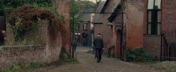 Movie still from “The Imitation Game” (2014), directed by Morten Tyldum – A man walking down a brick path in a city; Wide shot, High angle