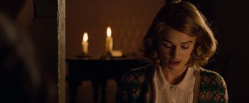 Movie still from “The Imitation Game” (2014), directed by Morten Tyldum – A woman sitting in front of candles in a room; Close Up shot, Over the shoulder angle