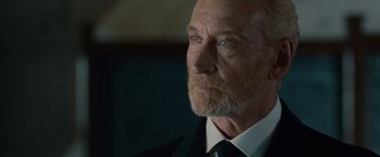 Movie still from “The Imitation Game” (2014), directed by Morten Tyldum – An older man in a black suit and white shirt; Close Up shot, Over the shoulder angle