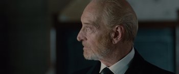 Movie still from “The Imitation Game” (2014), directed by Morten Tyldum – An older man wearing a suit and tie looking to his left; Close Up shot, Low angle